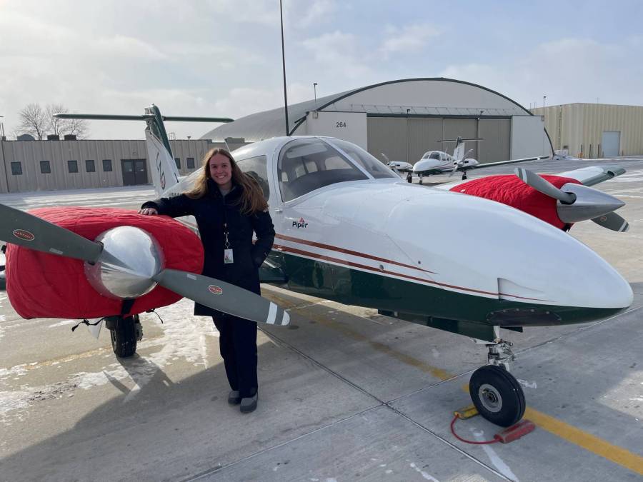 Erika smiles as she stands in front of a Piper Seminole, the small aircraft she received her multi-engine rating in.